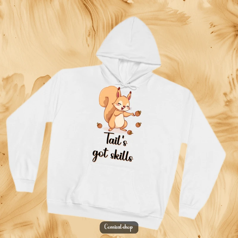 Funny hoodie depicting an energetic squirrel expertly juggling acorns with its tail, inviting a sense of playful wonder.