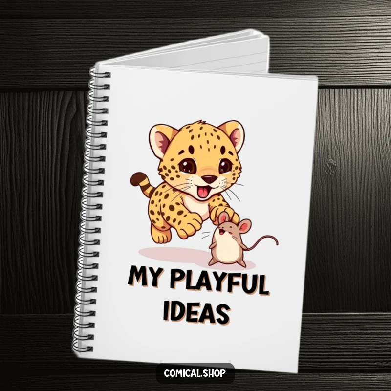 Funny cheetah cub excitedly pouncing on a bouncing toy mouse on a notebook, ideal for journaling.